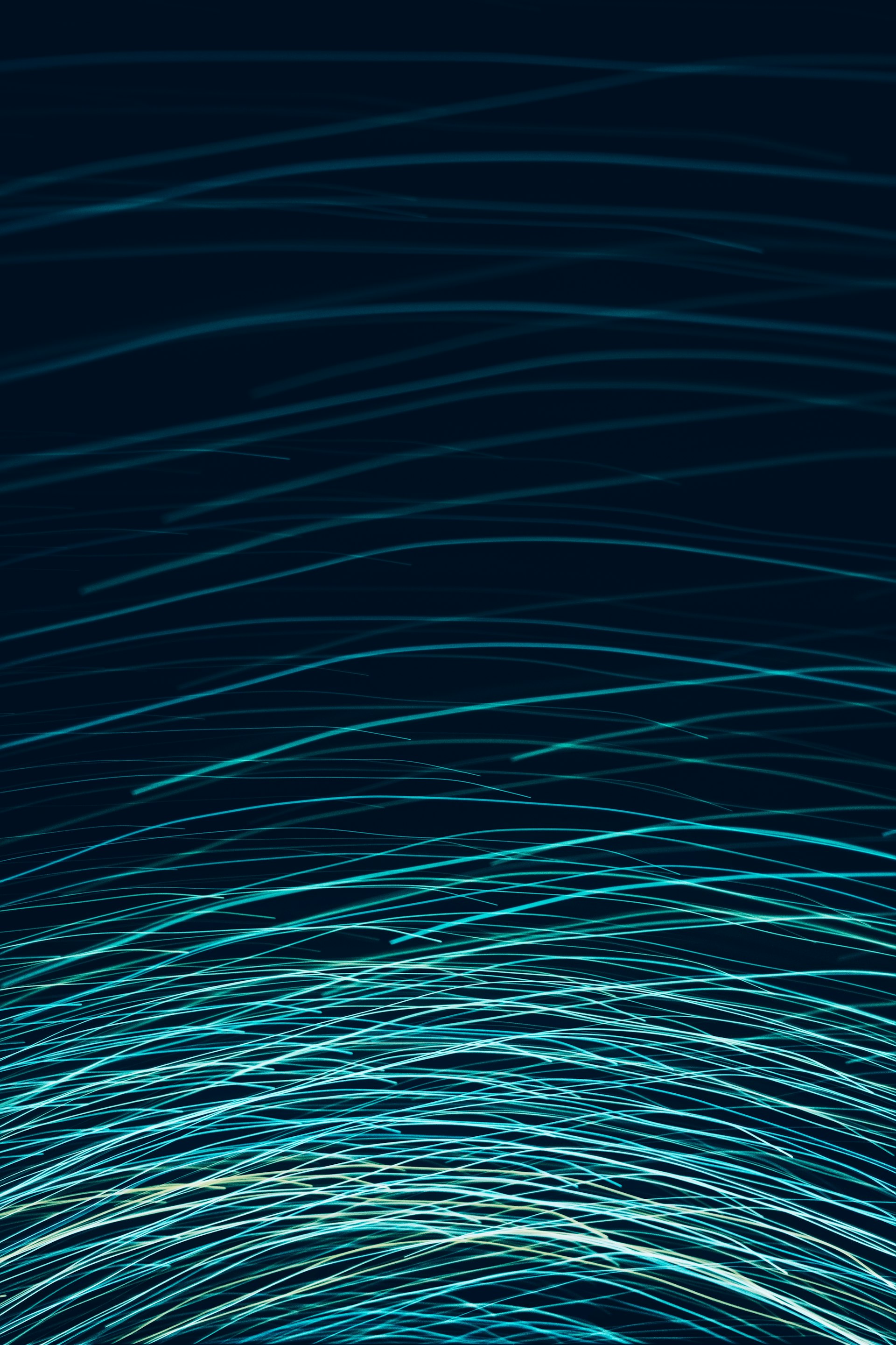 Blue and teal light streaks on a dark background